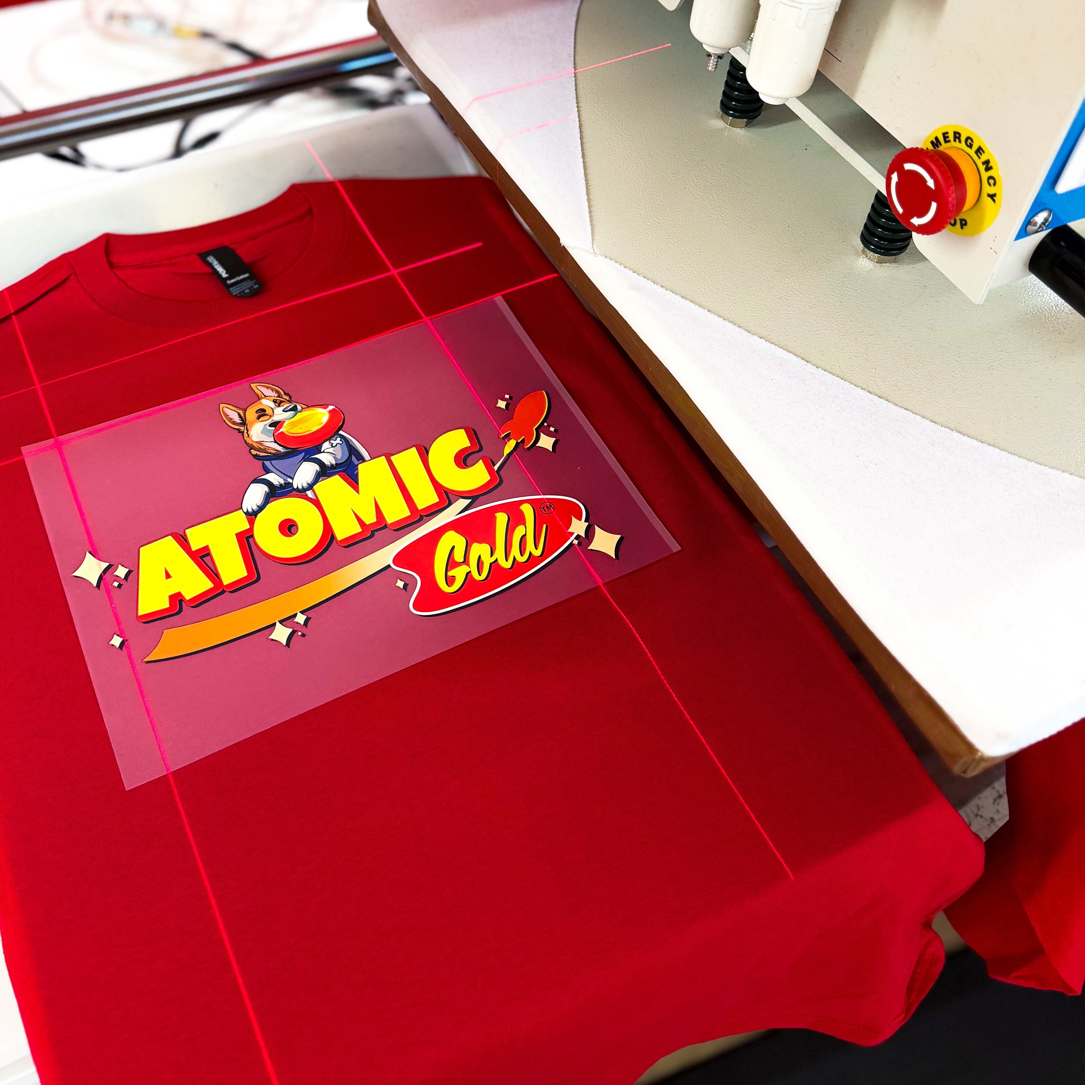 Heat press applying a colorful transfer to a red shirt
